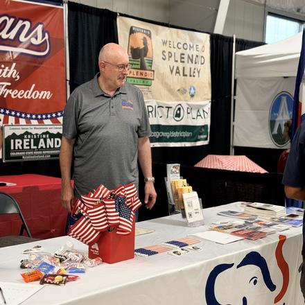Craig Sullivan talking with visitors in front of the booth