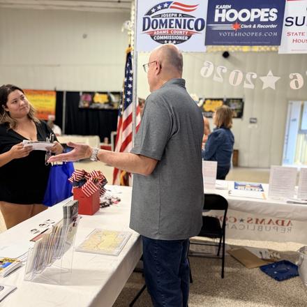 A fairgoer taking campaign literature at the booth