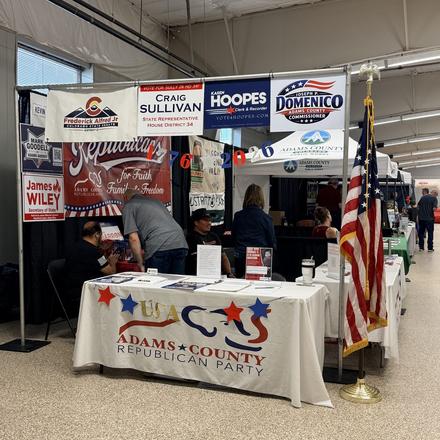 The booth table with the House District 34 banner overhead