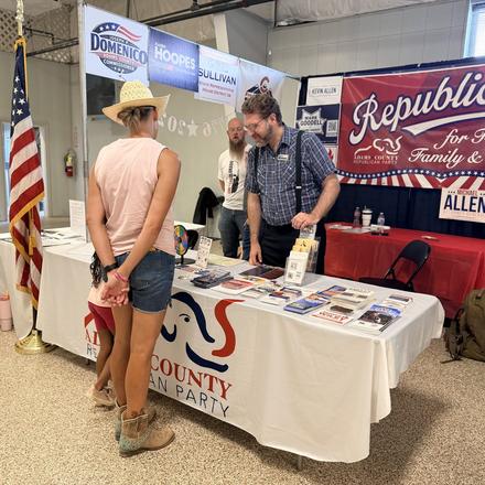 A fairgoer looking over the literature at the booth