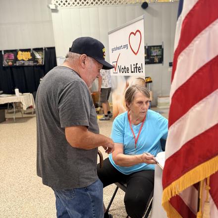 A fairgoer stopping at the booth table