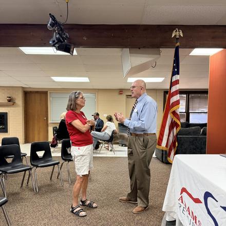 Craig Sullivan talking with a member near the front of the room