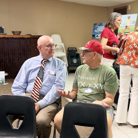 Craig Sullivan seated with a member during the meeting