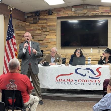 Craig Sullivan at the microphone in front of the Adams County Republican Party banner