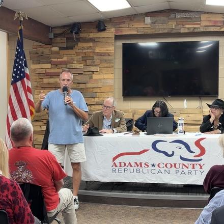 A speaker taking the microphone at the county party meeting