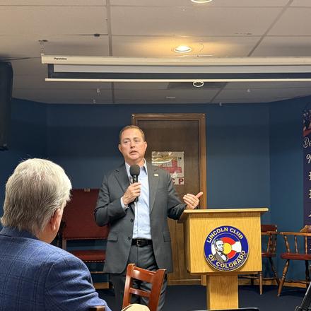 A speaker addressing the room, seen from the audience