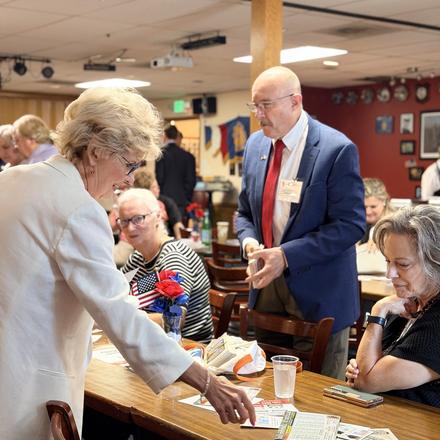 Craig Sullivan standing with guests at one of the lunch tables