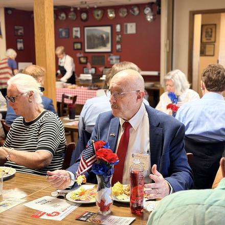 Craig Sullivan seated at a table with guests over lunch