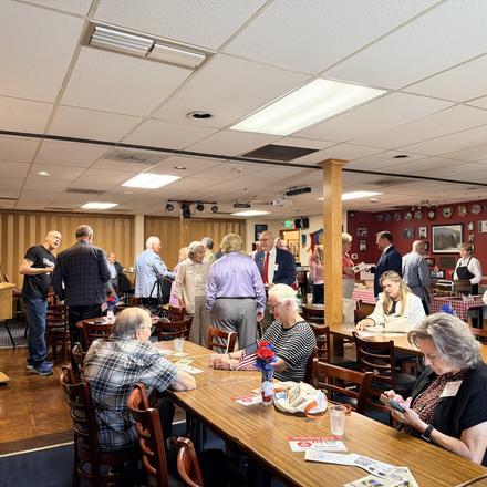 Guests finding seats at the long tables before the program