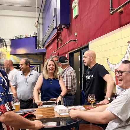 A group gathered around one of the tables at the meet and greet