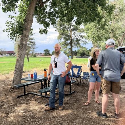 Guests at the picnic tables under the cottonwoods